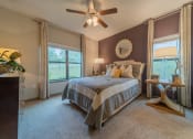 Thumbnail 7 of 21 - a bedroom with a bed and a ceiling fan