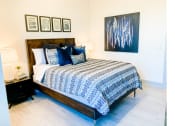 Thumbnail 10 of 34 - a bedroom with a bed and a nightstand