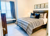Thumbnail 9 of 34 - a bedroom with a bed and a window