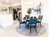 Thumbnail 7 of 34 - a dining area with a table and chairs and a kitchen in the background