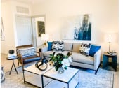 Thumbnail 2 of 34 - a living room with a gray couch and blue and white pillows