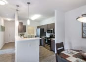 Thumbnail 5 of 21 - a kitchen and a dining room with a table and chairs