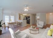 Thumbnail 1 of 34 - a living room and kitchen with white furniture and a ceiling fan at 10X Audubon Park apartments in Daphne, AL 