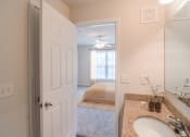 Thumbnail 9 of 34 - a bathroom with a sink and a bedroom in the background at 10X Audubon Park apartments in Daphne, AL 
