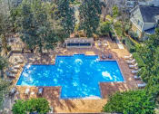 Thumbnail 2 of 34 - a view of the pool from above   the pool is surrounded by trees at 10X Audubon Park apartments in Daphne, AL 