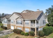 Thumbnail 29 of 34 - the front of a house with bushes and trees at 10X Audubon Park apartments in Daphne, AL 