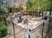 Thumbnail 19 of 34 - A black fenced in area with a fire pit and chairs at 10X Audubon Park apartments in Daphne, AL 