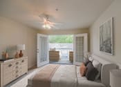 Thumbnail 8 of 34 - a bedroom with a bed and a ceiling fan at 10X Audubon Park apartments in Daphne, AL 