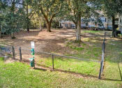 Thumbnail 17 of 34 - a fenced in yard with trees and houses in the background at 10X Audubon Park apartments in Daphne, AL 