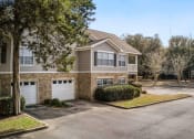 Thumbnail 32 of 34 - A residential building with a driveway and garage doors at 10X Audubon Park apartments in Daphne, AL 