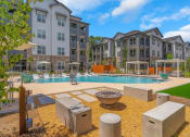 Thumbnail 15 of 50 - an outdoor swimming pool with outdoor game space and cabanas at Tapestry Overbrook in McDonough, Georgia