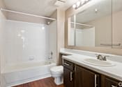 Thumbnail 9 of 9 - A white bathroom with a white tub, sink, and toilet.