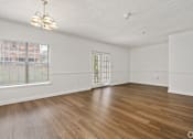 Thumbnail 6 of 9 - A room with wooden floors and a window with blinds.