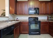 Thumbnail 1 of 18 - a kitchen with black appliances and wooden cabinets