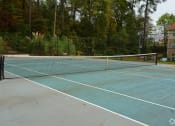 Thumbnail 14 of 18 - a tennis court with a net on a sidewalk
