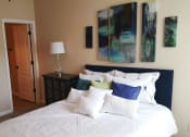 Thumbnail 6 of 18 - a bedroom with a white bed and paintings on the wall