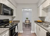 Thumbnail 5 of 26 - Kitchen with white cabinets and granite countertops  at Mirabelle Apartments in Mobile, Alabama