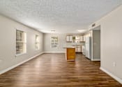 Thumbnail 6 of 9 - a living and kitchen area with hardwood floors and white walls