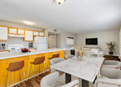 Thumbnail 5 of 9 - a kitchen with a long counter and a table with chairs