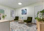 Thumbnail 13 of 24 - a living room with two green chairs and a blue and white rug