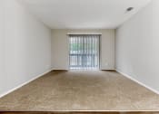 Thumbnail 18 of 24 - a spacious bedroom with a sliding glass door and carpeted flooring