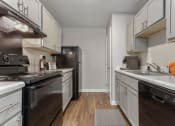 Thumbnail 2 of 24 - a kitchen with white cabinets and black appliances