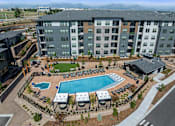 Thumbnail 47 of 58 - A large apartment complex with a pool and a mountain range in the background.