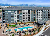Thumbnail 57 of 58 - A large apartment complex with a pool and a view of the mountains.
