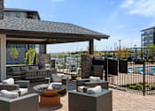 Thumbnail 45 of 58 - A patio with a fire pit and seating area.