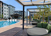 Thumbnail 53 of 58 - A pool area with a table and chairs under a canopy.
