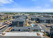 Thumbnail 27 of 58 - A large building complex with a parking lot in front.