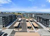 Thumbnail 32 of 58 - A parking lot with several cars and apartment buildings in the background.