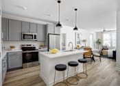 Thumbnail 1 of 22 - A modern kitchen with a white island and stools.