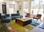 Thumbnail 8 of 26 - Clubhouse seating area with navy blue sofas and coffee table on colorful area rug in center of room