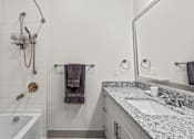 Thumbnail 10 of 25 - Bathroom with granite countertop and subway tile shower at Avion at West Lemmon Apartments, Dallas, TX