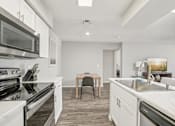 Thumbnail 2 of 29 - A modern kitchen with a dining table and chairs.