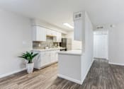 Thumbnail 9 of 18 - an open kitchen with white cabinets and a plant in a vase at Stonebridge, Phoenix, AZ