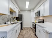 Thumbnail 8 of 18 - a renovated kitchen with white cabinets and stainless steel appliances at Stonebridge, Phoenix, AZ, 85032