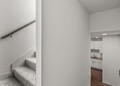 Thumbnail 12 of 25 - Interior hallway with staircase and kitchen view at Avion at West Lemmon Apartments, Dallas, Texas
