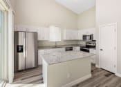 Thumbnail 16 of 29 - a kitchen with white cabinets and a granite counter top