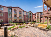 Thumbnail 24 of 25 - A row of apartment buildings with a bench in front of them.