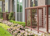 Thumbnail 15 of 23 - Decorative metal fencing with landscaped flower beds at Matilda at Lower Greenville Apartments, Dallas, TX