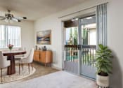 Thumbnail 8 of 19 - a living room with a patio door and a table and chairs