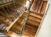 Thumbnail 14 of 23 - Wooden staircase with metal railing and landing at Matilda at Lower Greenville Apartments, Dallas