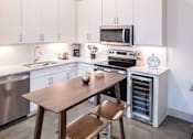 Thumbnail 11 of 25 - Modern kitchen with granite countertops and island at Avion at West Lemmon Apartments, Dallas, 75235