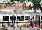 Thumbnail 22 of 23 - Outdoor bar with vintage airstream and patio seating at Matilda at Lower Greenville Apartments, Dallas, TX 75206