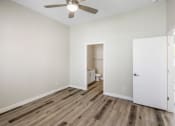 Thumbnail 19 of 29 - a bedroom with hardwood floors and a ceiling fan