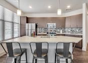 Thumbnail 25 of 25 - A modern kitchen with a white island and chairs.