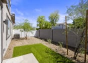 Thumbnail 10 of 29 - a backyard with a grassy area and a fence