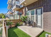 Thumbnail 2 of 25 - Private patio with artificial turf and seating at Avion at West Lemmon Apartments, Dallas